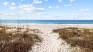 A sandy beach with a clear sky and ocean in the background. - 20816 Front Beach Rd (Panama City Beach)