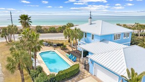 A blue house with a swimming pool, a covered patio, and a view of the ocean. - 20816 Front Beach Rd (Panama City Beach)
