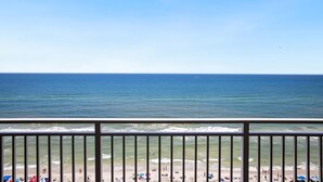 A beach with a clear view of the ocean and a balcony railing. - Emerald Beach 1430 (Panama City Beach)