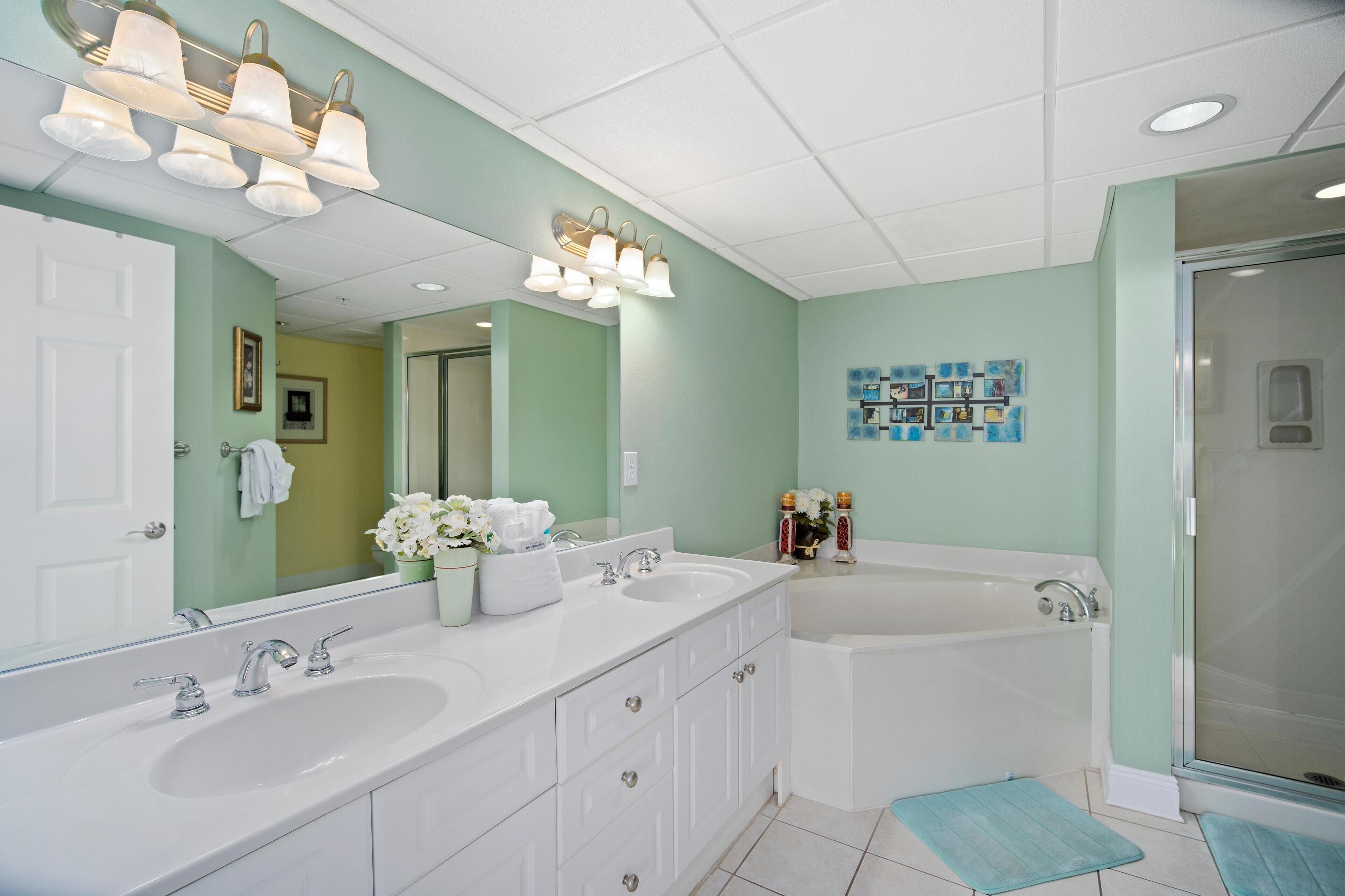 A bathroom with two sinks, a bathtub, and a shower.