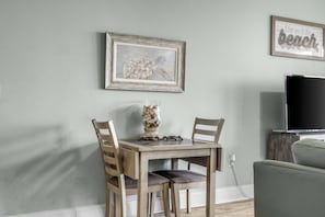 A dining area with a wooden table and chairs, a vase with stones, and a framed picture of a turtle on the wall. - Laketown Wharf 1331 (Panama City Beach)