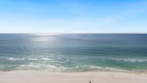 Une plage avec un ciel dégagé et une mer calme.