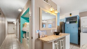 Eine Küche mit einer zentralen Kochinsel, einem Kühlschrank und einem blauen Schrank.
