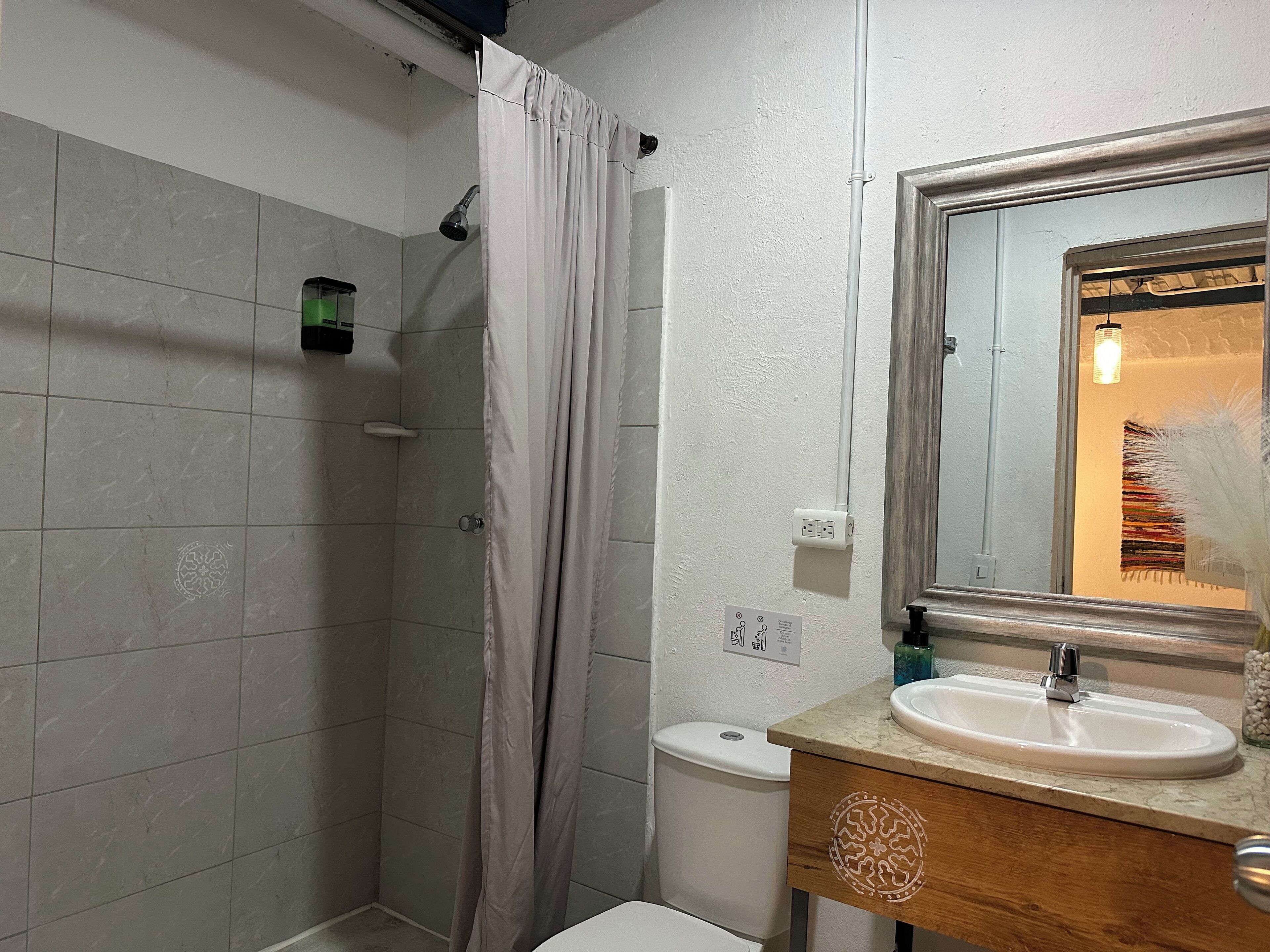 A bathroom with a shower, toilet, and sink.
