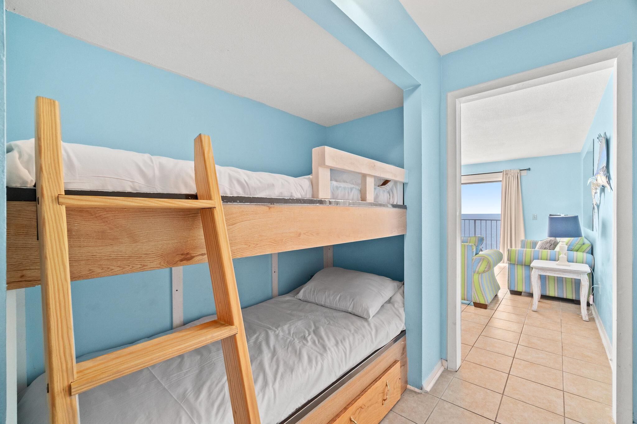 Una stanza con un letto a castello, un divano e un tavolino.