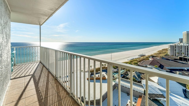 Ein Balkon mit Blick auf Strand und Meer.