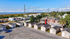 A campground with RVs and mobile homes, a parking lot, and a view of the ocean. - Plush King Bed Xtra Clean Stay
 (Canal Point)