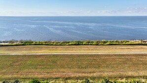 A coastal landscape with a road and fields. - Plush King Bed Xtra Clean Stay
 (Canal Point)