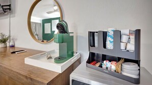 A hotel room with a coffee machine, a mirror, and a shelf with toiletries. - Plush King Bed Xtra Clean Stay
 (Canal Point)