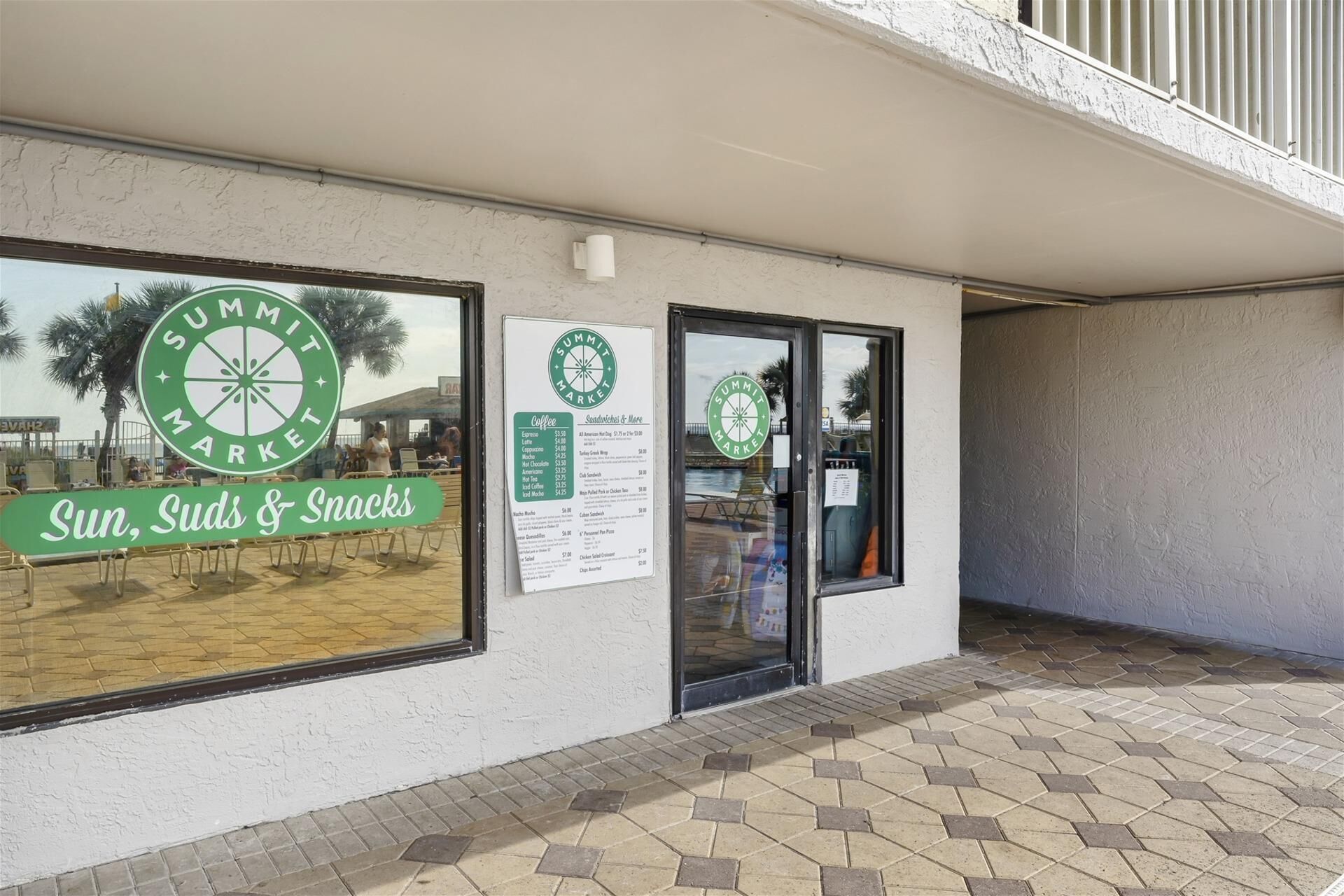 Une devanture de magasin avec une enseigne indiquant « Summit Market » et un panneau affichant le menu.