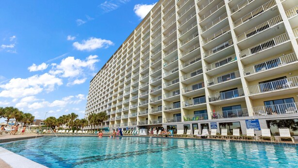Um hotel grande com várias varandas com vista para uma piscina.