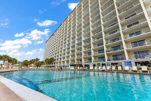 Un grand hôtel doté de nombreux balcons donnant sur une piscine.