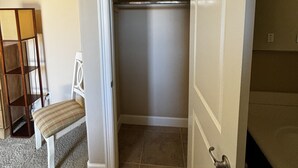 A room with a closed door, a bench, and a shelving unit.