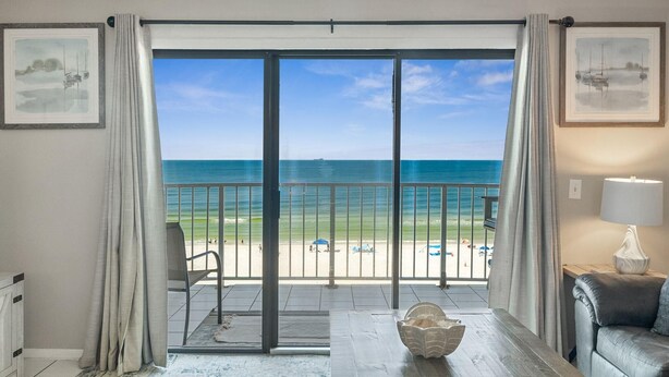 A room with a large sliding glass door leading to a balcony with a view of the beach and ocean. - The Summit 725 (Panama City Beach)