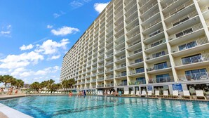 A large hotel with multiple balconies overlooking a swimming pool. - The Summit 725 (Panama City Beach)