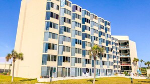 Un hotel de varios pisos con un diseño moderno, que cuenta con balcones y grandes ventanales.