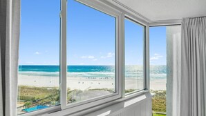 A room with large windows overlooking a beach. - Top Of The Gulf 613 (Panama City Beach)