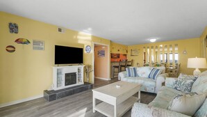 Ein Wohnzimmer mit Kamin, Fernseher und Sofa.