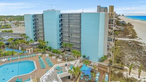 Ein Hotel mit Pool, Außenbereich und Blick auf den Strand.