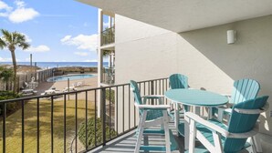 Ein Balkon mit Pool, Stühlen und einem Tisch.