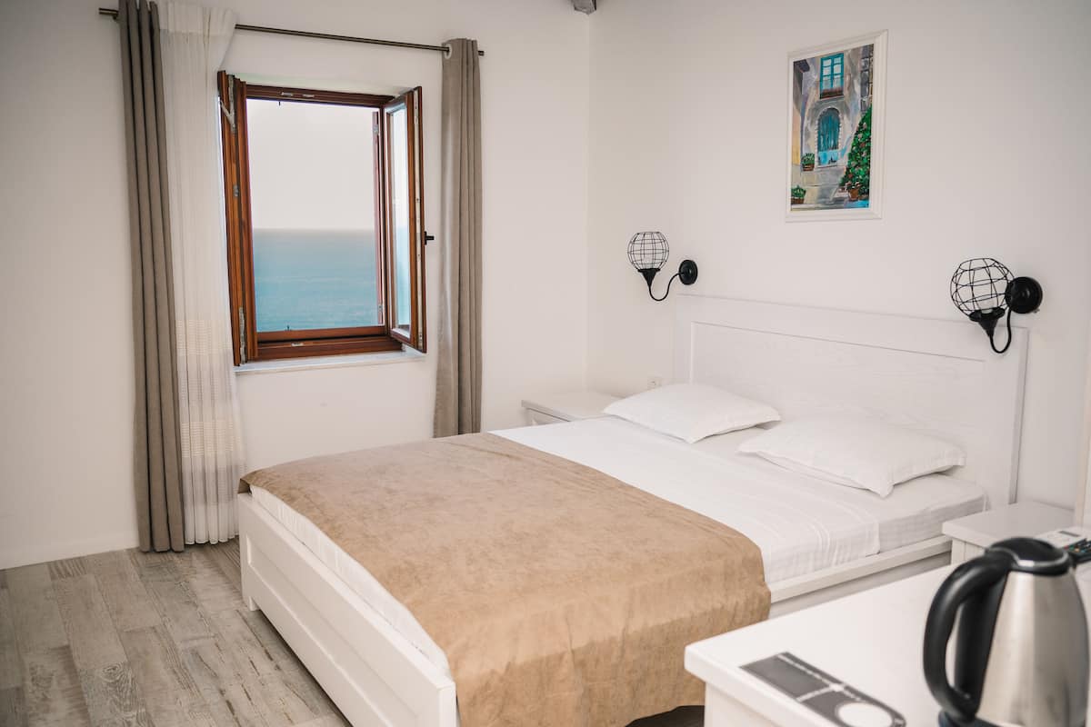Habitación panorámica doble, 1 cama de matrimonio, baño privado, vistas al mar | Zona de estar | Televisión de pantalla plana de 65 pulgadas con canales por satélite
