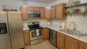 A modern kitchen with stainless steel appliances, wooden cabinets, and a marble countertop. - Olive Tree Oasis - 10 Minutes to the Ark!
 (Dry Ridge)