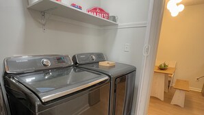 A compact kitchen with a stainless steel stove, a microwave, and a small wooden table with a bowl. - Olive Tree Oasis - 10 Minutes to the Ark!
 (Dry Ridge)