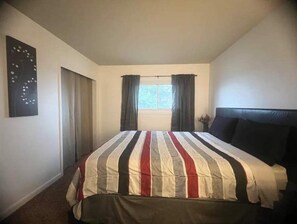Cozy retreat with a single bed, window, and potted plant.