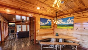 Un interior de madera con comedor, bancos y chimenea.