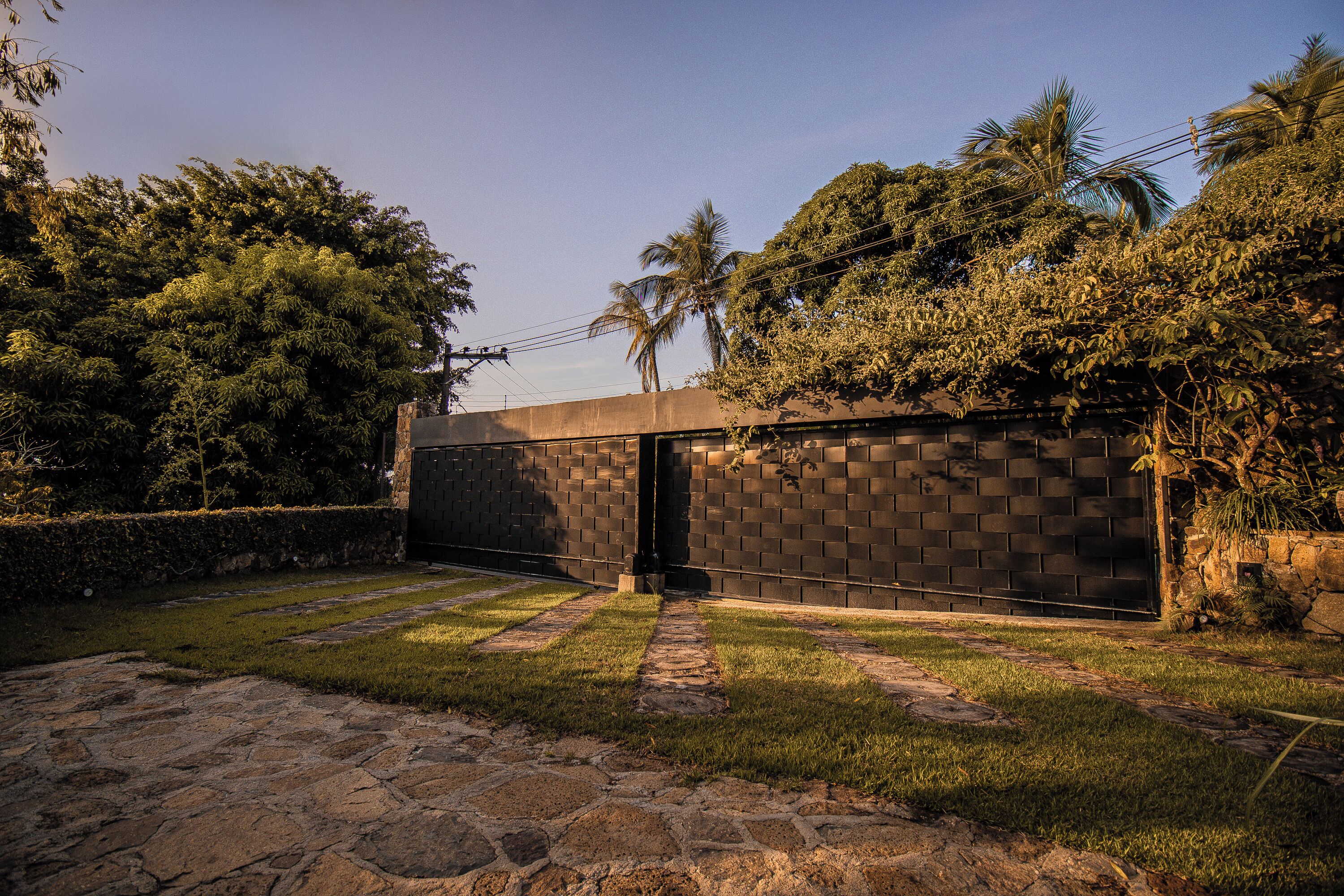 A modern building with a brick wall and a paved entrance area.