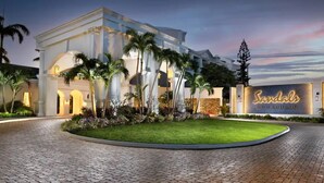 A hotel entrance with a well-maintained lawn, palm trees, and a sign reading "Sandals Royal Bahamian". - NEWLy RENOVaTED! COMPLImentary CAR! Casa Bonita! (Nassau)