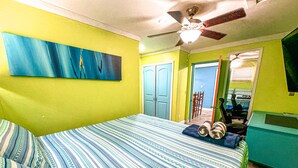 A bedroom with a bed, a ceiling fan, and a door leading to another room. - COMPLimentary Car! Casa Azul! (Nassau)