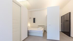 A bedroom with a bed, a radiator, and a door. - Loft Piazza Marina (Palermo)