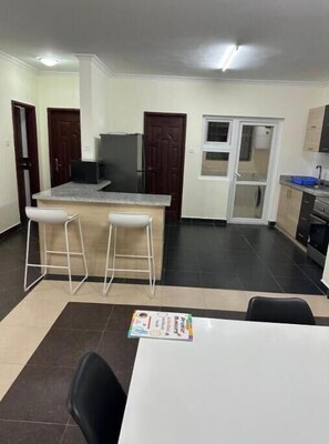 Enjoy meals at the central island with microwave and sink, then dine at the adjacent table with comfortable seating for two.