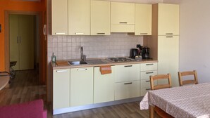 A compact kitchen with light yellow cabinets, a stainless steel sink, and a coffee maker. - Bikeapt Two-bedroom apartment 3 with lake view and private parking a stone's throw from downtown (Malcesine)