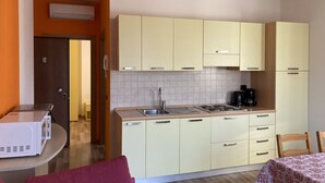 A compact kitchen with light-colored cabinets, a sink, and a coffee maker. - Bikeapt Two-bedroom apartment 3 with lake view and private parking a stone's throw from downtown (Malcesine)