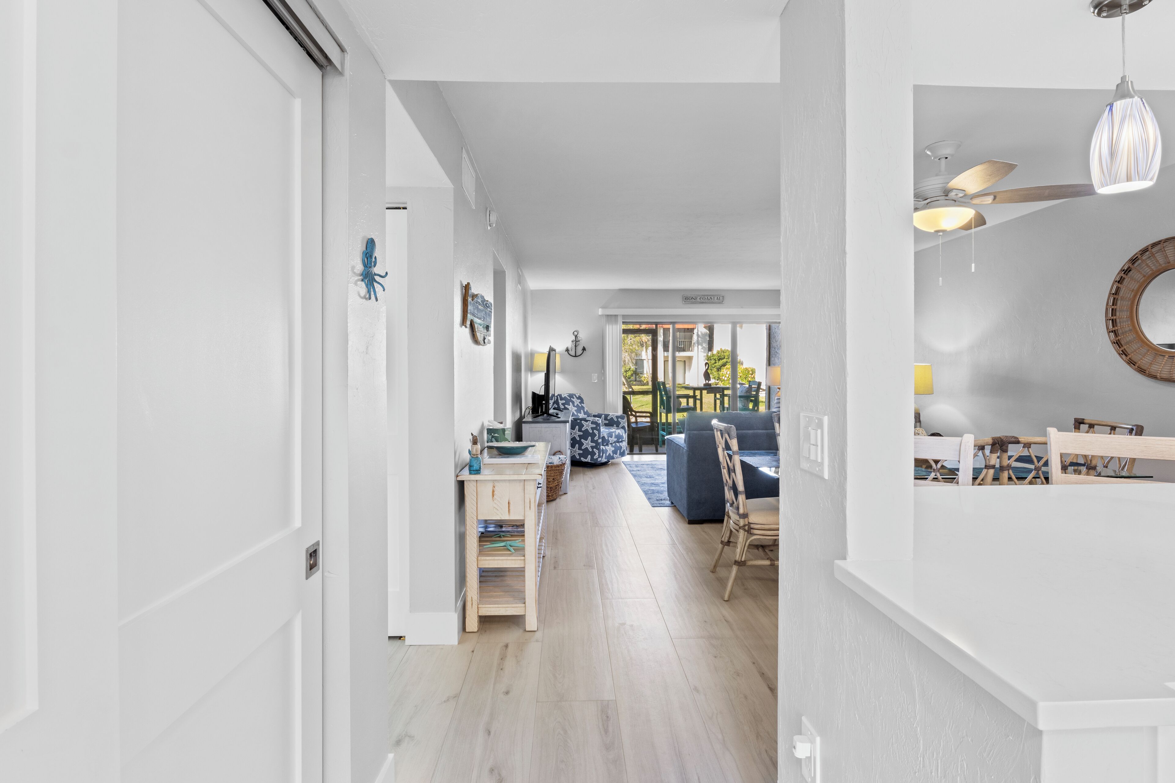 Ein modernes Interieur mit Holzboden, weißen Wänden und einem Essbereich mit Tisch und Stühlen.