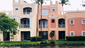 Un edificio de varios pisos con balcones y un pequeño estanque en la parte delantera.