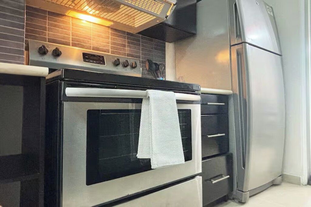 A kitchen with a stainless steel oven, a built-in microwave, and a refrigerator.