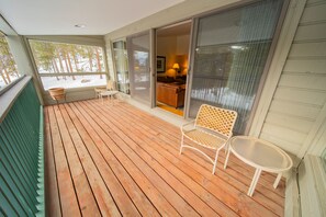 Enjoy the serene view from this cozy deck, where a comfortable chair and small table invite relaxation.