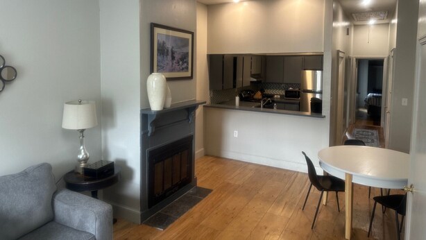 Una sala de estar moderna con chimenea, una mesa de comedor con sillas y una zona de cocina.