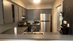 Una cocina moderna con electrodomésticos de acero inoxidable, microondas y cocina a gas.
