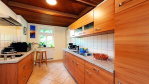 A kitchen with wooden cabinets, a countertop, a window, and a radiator.
