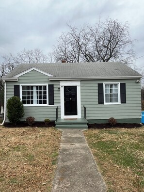 A single-story house with a front porch, a black front door, and a small front yard. - 🥤The Coca Cola House 🥤 (Roanoke)