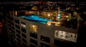 A high-rise hotel with a rooftop swimming pool, multiple balconies, and a city view. - Enjoy an upscale stylish experience at this centrally located apartment. (San José)