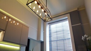 A modern kitchen with a built-in oven, a toaster, and a potted plant. - Claremont The Corson (Leeds)
