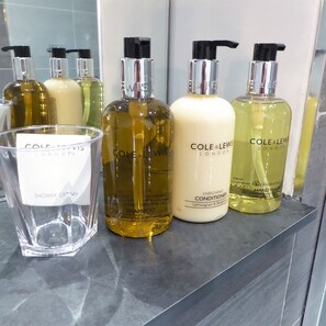 A bathroom shelf with various personal care products from Cole & Lewish. - Claremont The Matcham (Leeds)