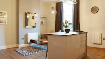 Departamento | 1 habitación, escritorio y tabla de planchar con plancha