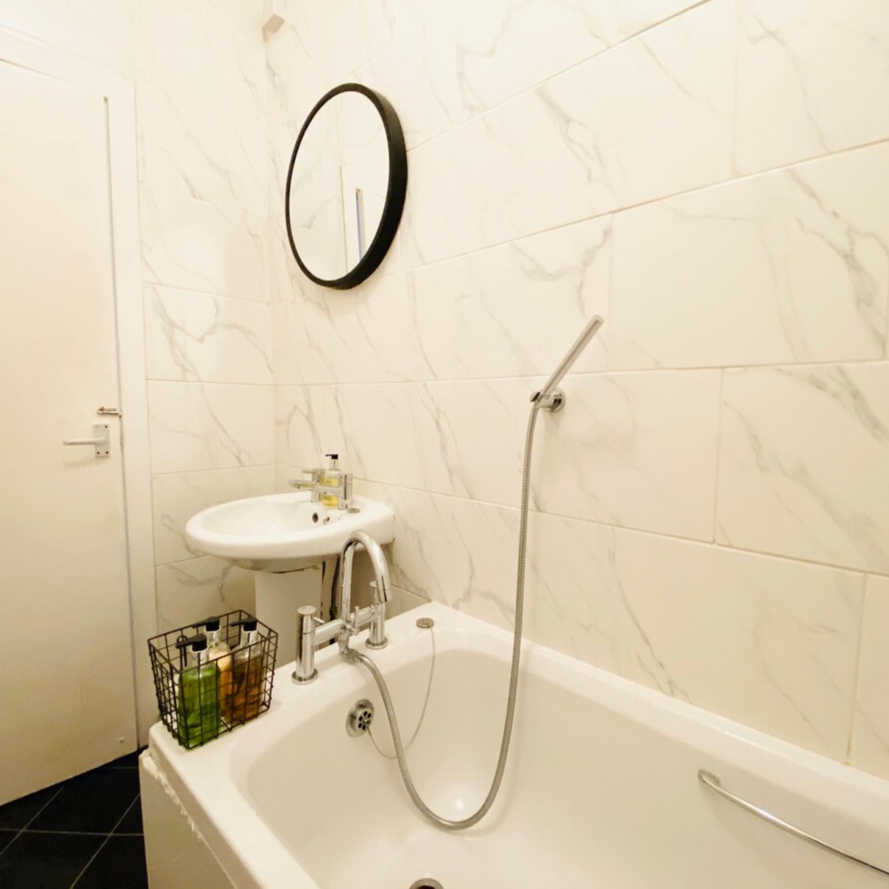 Un baño con bañera, lavamanos y ducha.
