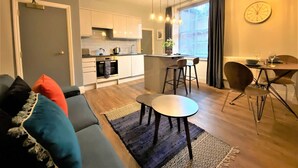 A modern apartment with a kitchen, dining area, and living room. - Claremont The Smeaton (Leeds)